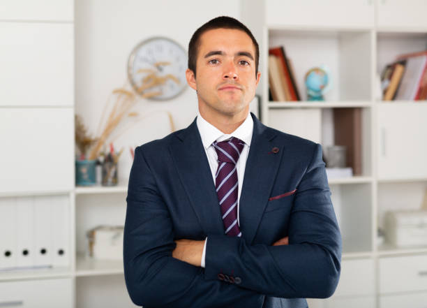 Successful businessman with arms crossed in office interior