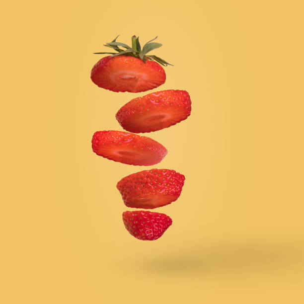 istock Creative composition with sliced strawberry flying in the air isolated on a bright blue background. 1365664447