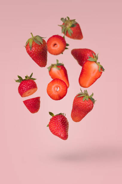istock Creative composition with flying ripe strawberries on a bright pink background. 1365664450