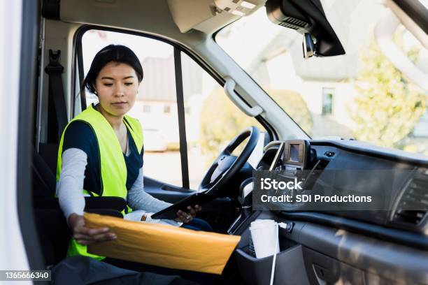 Delivery Driver Reads Address On Package Stock Photo - Download Image Now - Delivery Person, Driver - Occupation, Envelope