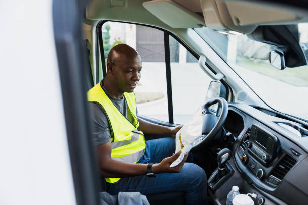 istock Delivery person reads address on envelope 1365666373