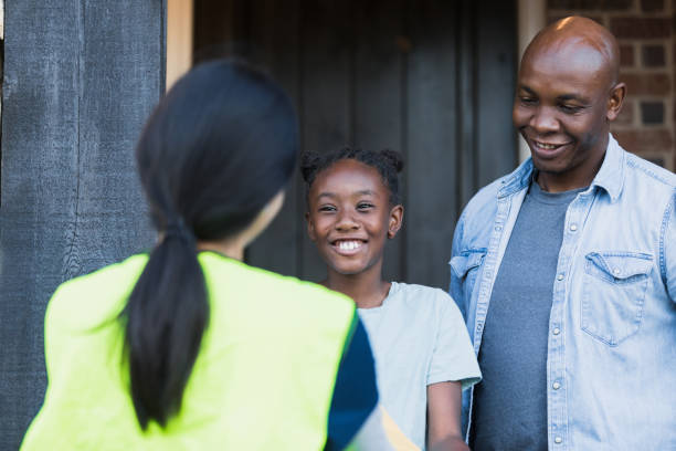 istock Young girl and father smile while chatting with postal worker 1365666668