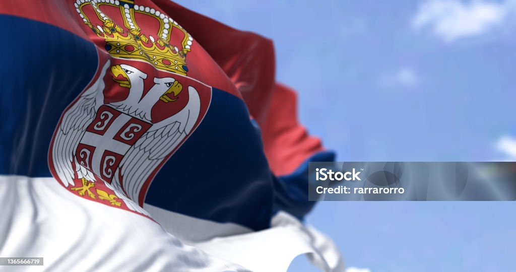 Detail of the national flag of Serbia waving in the wind Detail of the national flag of Serbia waving in the wind on a clear day. Democracy and politics. European country. Selective focus. Serbia Stock Photo