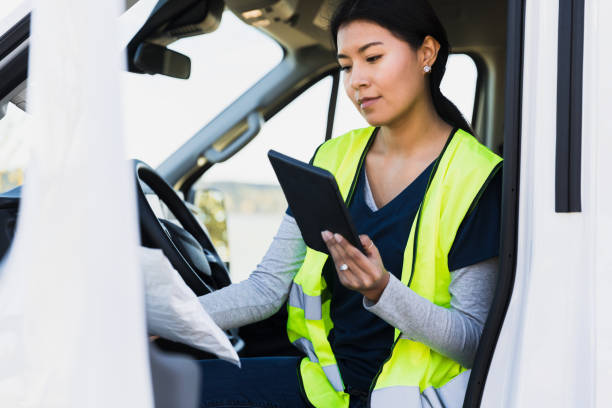 istock Exiting delivery van, young woman checks package address on tablet 1365666777