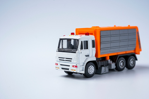 Toy car garbage truck with orange body, on a white background.