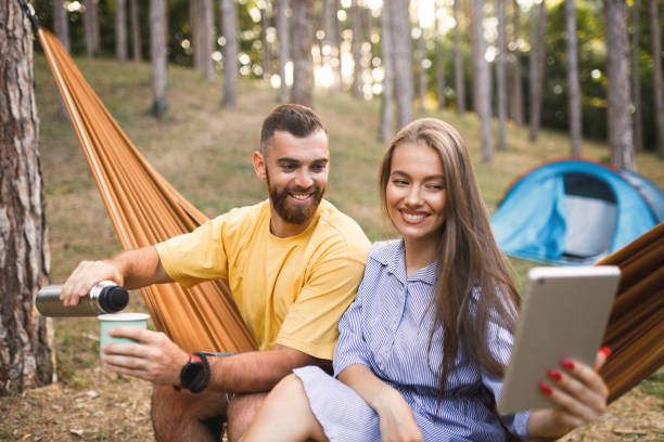 istock Traveler nomadic couple having video call while camping in  forest 1365672789