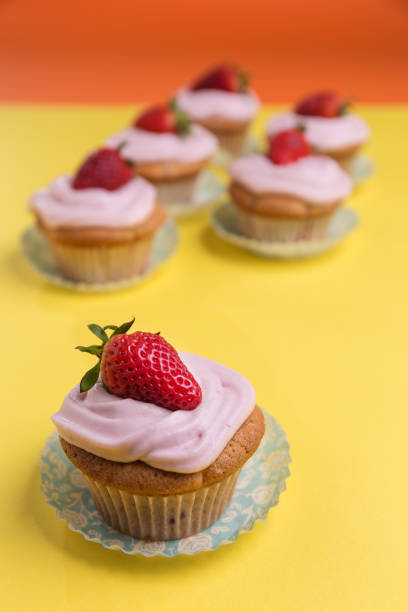 istock Natural strawberry cupcake and cream on yellow background 1365672974