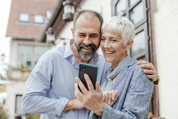 istock Mature couple is spending time together and using mobile phone on the street 1365674004