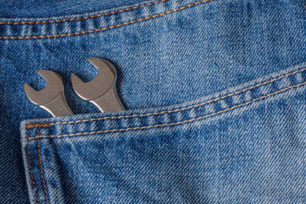 wrench in jeans pocket. Two wrenches in the back pocket of a pair of blue jeans.