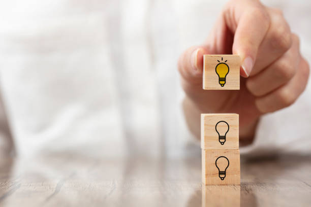 istock Concept creative idea and innovation. wooden cube block with light bulb icon. 1365675366