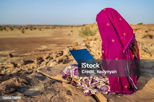 istock Happy Gypsy Indian girl using laptop, India 1365678894