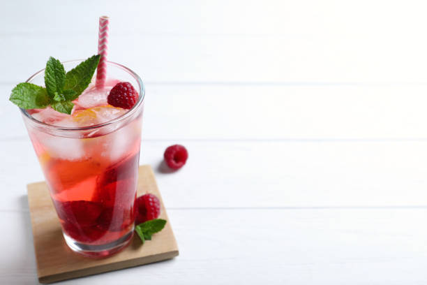 istock Delicious raspberry lemonade made with soda water and ingredients on white wooden table. Space for text 1365679096