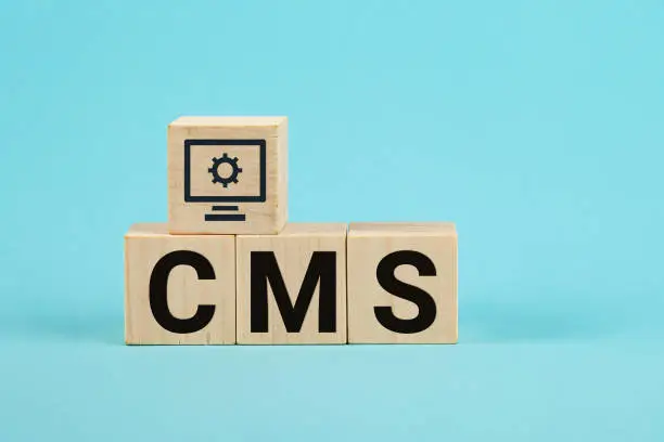 Photo of CMS acronym on woodblock cubes blue background, Frequently asked questions, Business customer service, and support concept. acronym CMS on wooden cubes Content Management System