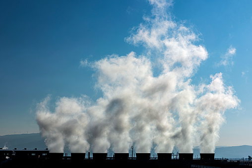 White dense steam rising from the chimneys of the power generation facility.