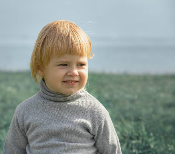 istock Child smiles face portrait on seashore background 1365685937