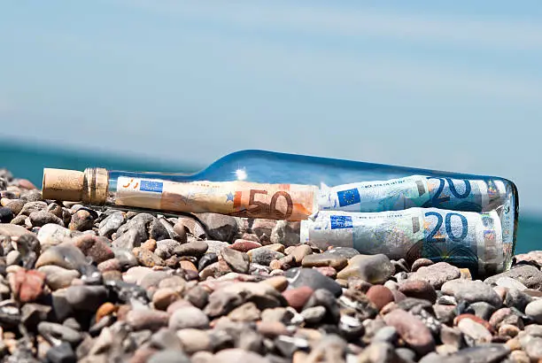 message in a bottle on the beach fullly with euronotes