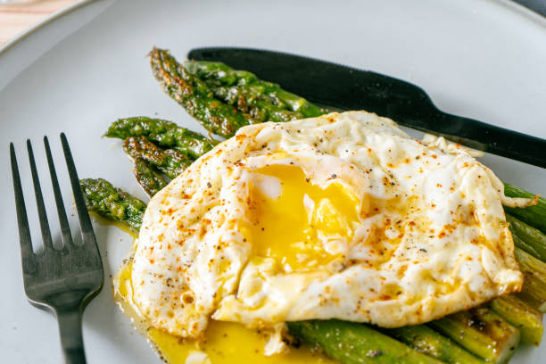 istock Exquisite cooked asparagus prepared with a fried egg, seasoned and spiced. Natural cuisine, Gourmet. Normal view, Close-up 1365689084