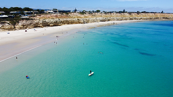 Port Willunga beach, South Australian coastline, Fleurieu Peninsula coast. Aerial drone view of the stunning Australian beach with crystal clear water, vibrant colours and calm seas. No waves