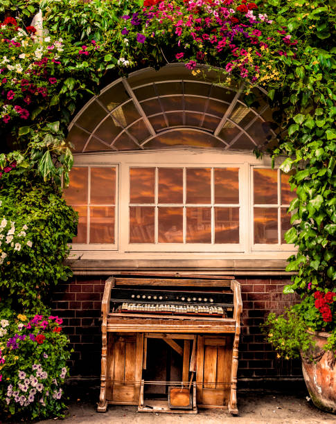 Fragment of facade of old georgian brick house with small window with white frame in the middle of the wall. Lace curtains