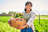 istock Portrait of a young woman carrying a crate of fresh produce on a farm 1365692557