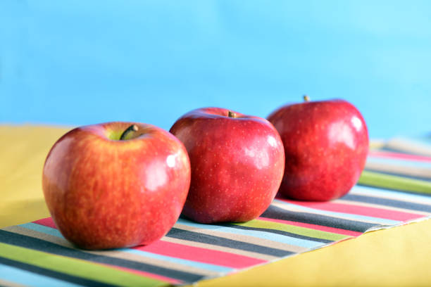 fotografía macro manzanas rojas aisladas sobre fondo coloreado con desenfoques - drop red delicious apple apple fruit fotografías e imágenes de stock