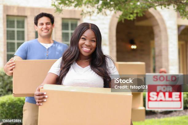 Excited Young Couple Moves Boxes Into Their New Home Stock Photo - Download Image Now