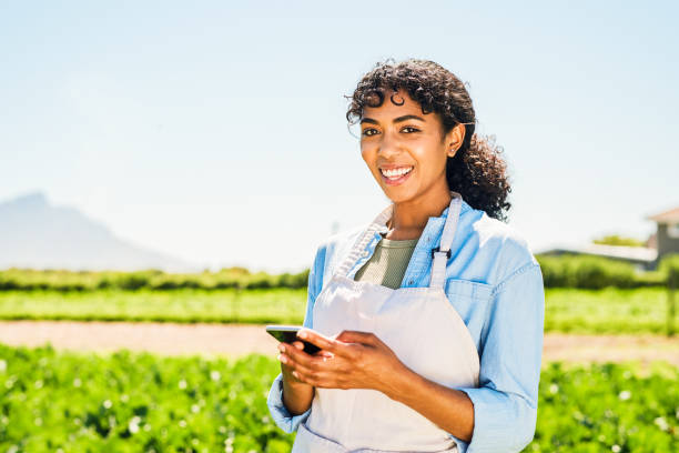 istock Portrait of a young woman using a cellphone while working on a farm 1365693914