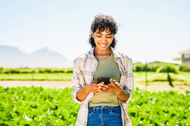 istock Shot of a young woman using a cellphone while working on a farm 1365693926