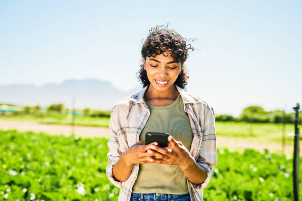 istock Shot of a young woman using a cellphone while working on a farm 1365693928