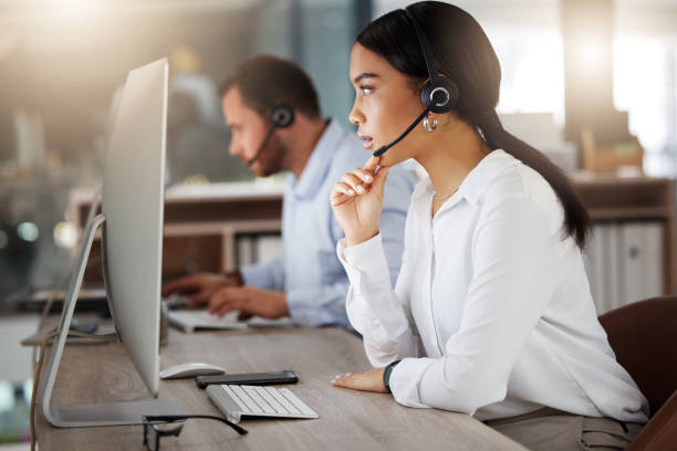 istock Shot of a young call centre agent working on a computer in an office at night 1365699515