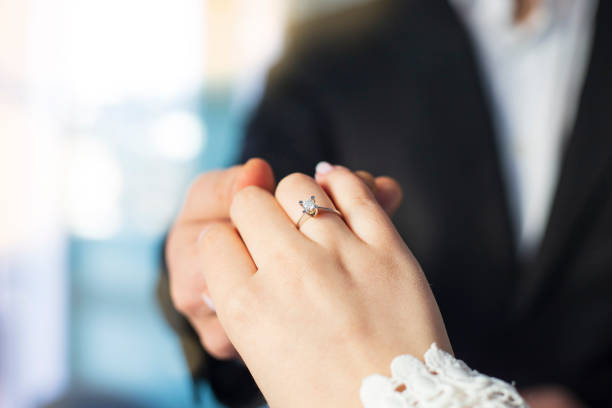 istock Groom Put on Wedding Ring Bride Hand 1365703002