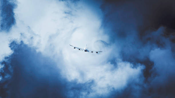 un grand avion décollant à travers les nuages créant un tourbillon de turbulences. journée orageuse et mauvaises conditions météorologiques - turbulence photos et images de collection