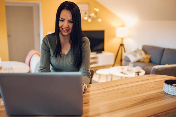 istock Middle aged woman using a laptop at home. 1365709742