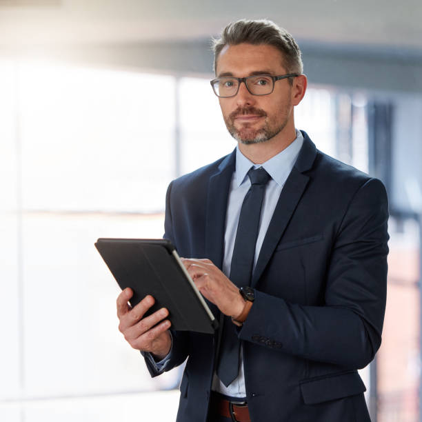 istock Portrait of a businessman using a digital tablet at the office 1365728956