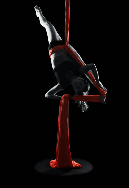 Young woman gymnast with red gymnastic aerial silks stock photo