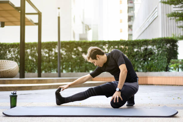 istock Asian sportsman making an exercise at a park. 1365736751