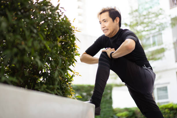 istock Asian sportsman making an exercise at a park. 1365736919