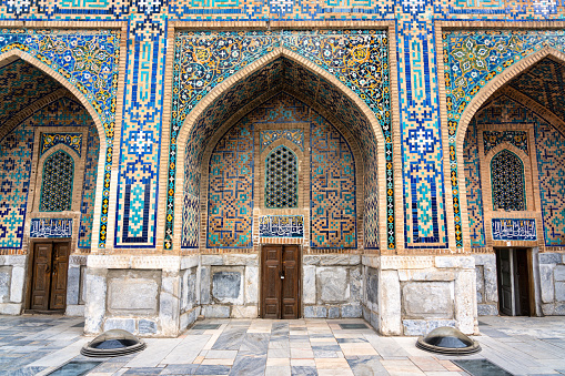 JUNE 24, 2023, SAMARKAND, UZBEKISTAN: Symmetrical decorative ornament of entrance to the tomb and open door in Shah-I-Zinda, a memorial complex, necropolis in Samarkand, Uzbekistan