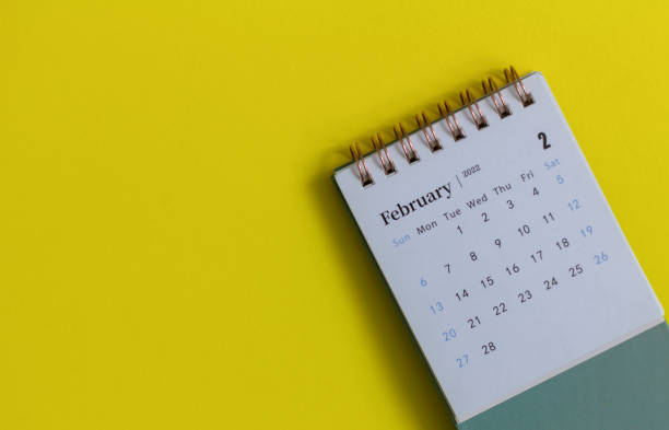 istock Desktop calendar for February 2022 on a yellow background. 1365741296