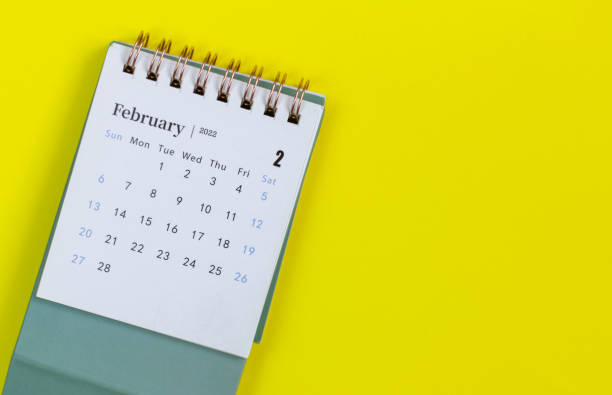 istock Desktop calendar for February 2022 on a yellow background. 1365741299