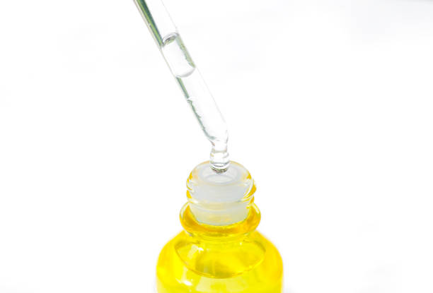 istock Dropping serum collagen moisturizer of face into clear yellow bottle soft light background. Protector skin Treatment facial essence oil, Vitamin C. Beauty and spa Concept 1365745828