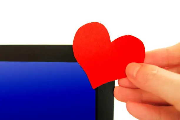 Heart Shape in the Hand on the Computer Screen Background
