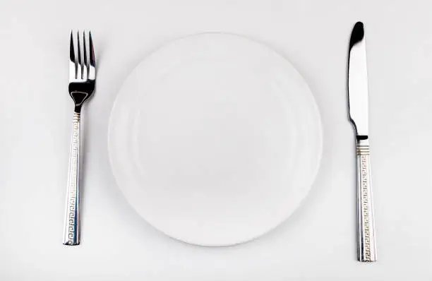 Empty Plate with a Cutlery on the White Table