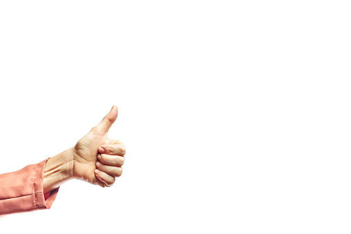 Hand showing thumb up sign against isolated on white background. Woman showing OK sign