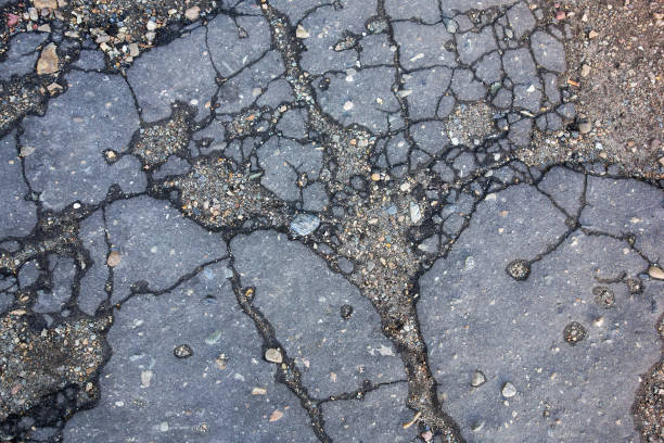 istock Background of cracked old asphalt. Texture 1365757113