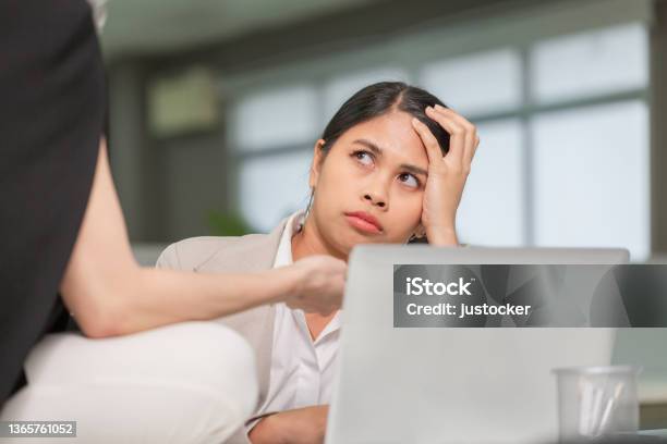 Woman Looking At Her Coworker With A Displeased Expression Woman Working In Her Office Stock Photo - Download Image Now