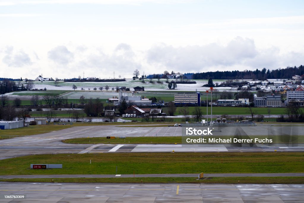 Wet runway at Zürich Airport on a cloudy winter day with snow capped mountains in the background. Photo taken January 8th, 2022, Zurich, Switzerland. Zurich Airport Stock Photo