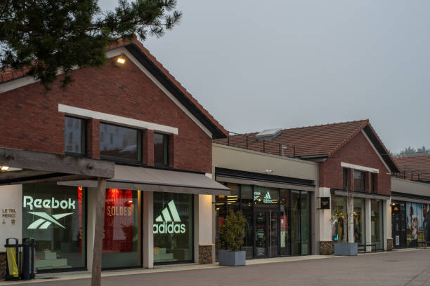 Paris cityscape Romainville, France - January 13 2022: Adidas and Reebok outlet store in Paddock Paris EST Factory Outlet village near Paris on a cloudy winter morning. reebok stock pictures, royalty-free photos & images