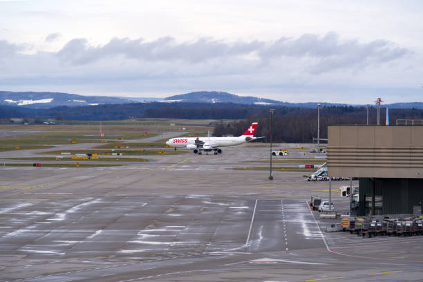 aéroport suisse zurich kloten avec fond de ciel nuageux. - runway airport sky wet photos et images de collection