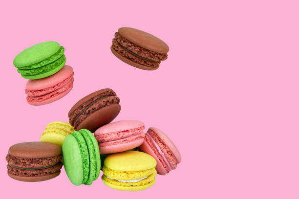 istock French macaroons flying in the air isolated on a pink background. 1365765728